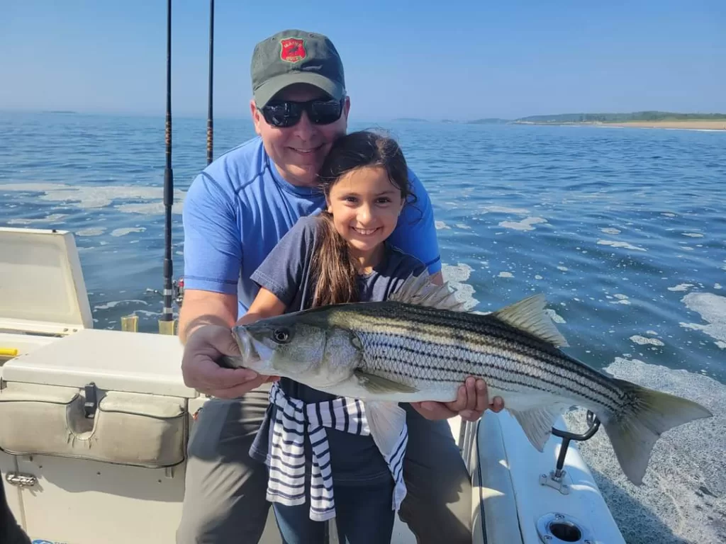 young girl holds up large fish