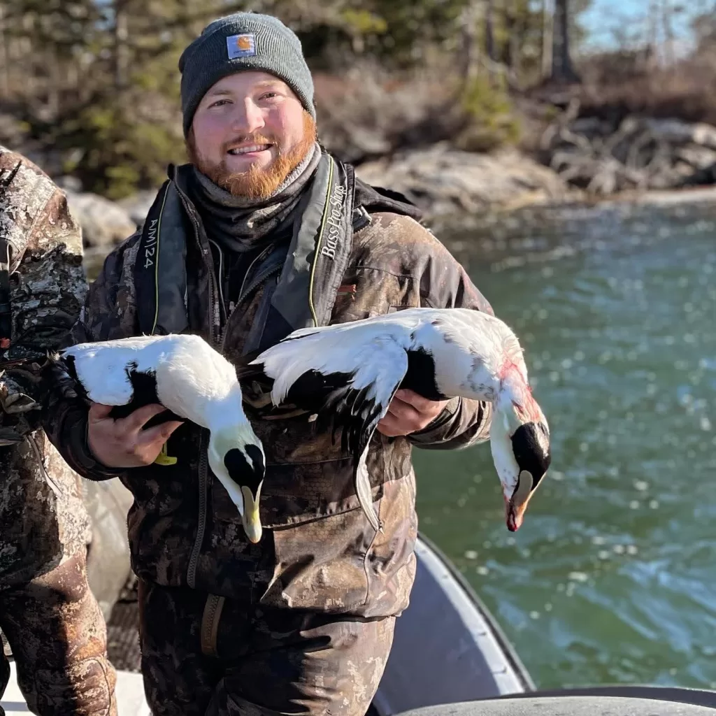 maine hunter posing with two birds after a successful hunt
